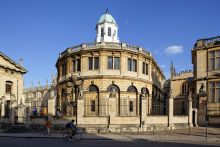 Photo of the Sheldonian Theatre exterior including striking octagonal cupola, against a bright blue sky