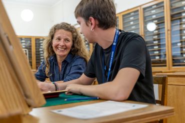 Photo of a tutor and student in conversation during an art session.