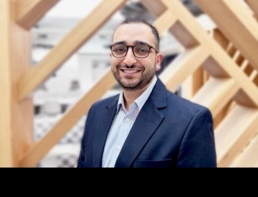 Benjamin Attia, a young man wearing a dark blue jacket and shirt, and glasses