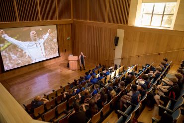Images shows school pupils in the lecture theatre during their afternoon education session. An image on the projector screen depicts David Beckham celebrating a goal.