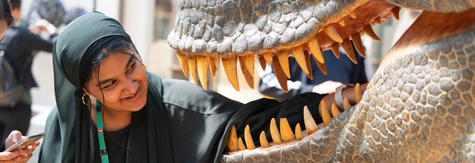 A student looks into the jaws of a dinosaur model at the Museum of Natural History.