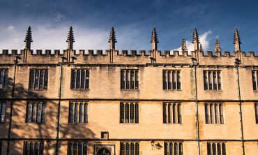 The side of the Bodleian Library against a blue sky