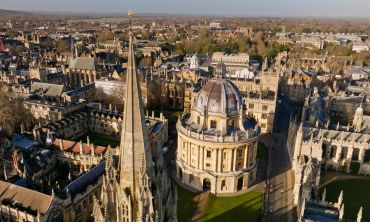 High angle aerial view of St Mary's Church and the Radcliffe Camera (a large ornate circular building) in Oxford.