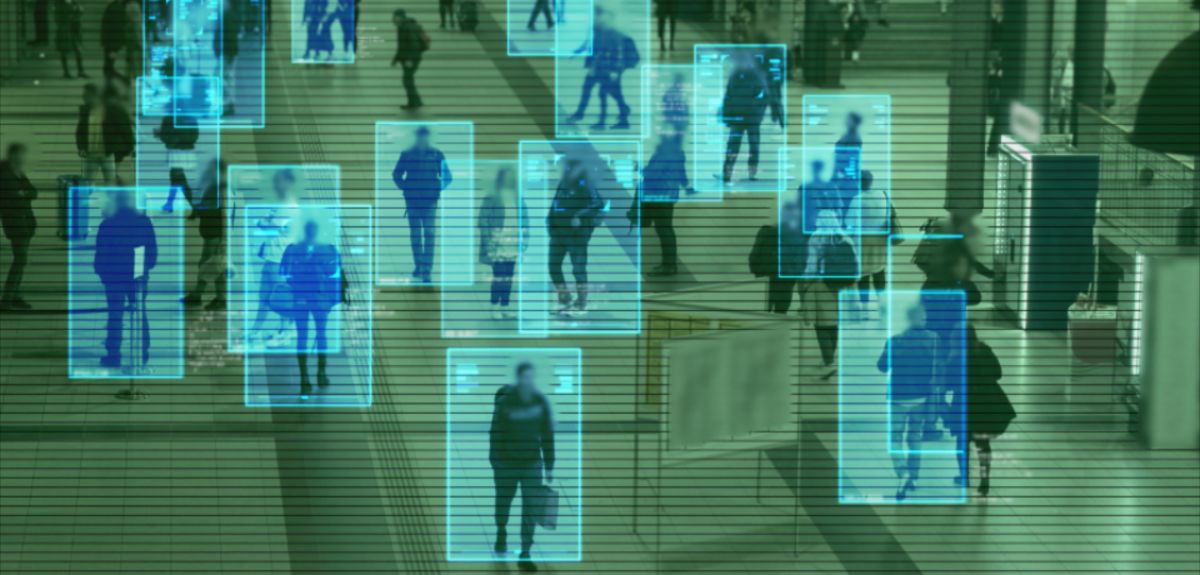 Overhead, ‘security camera-style’ shot of people walking in a building complex; each person is outlined by a blue box.