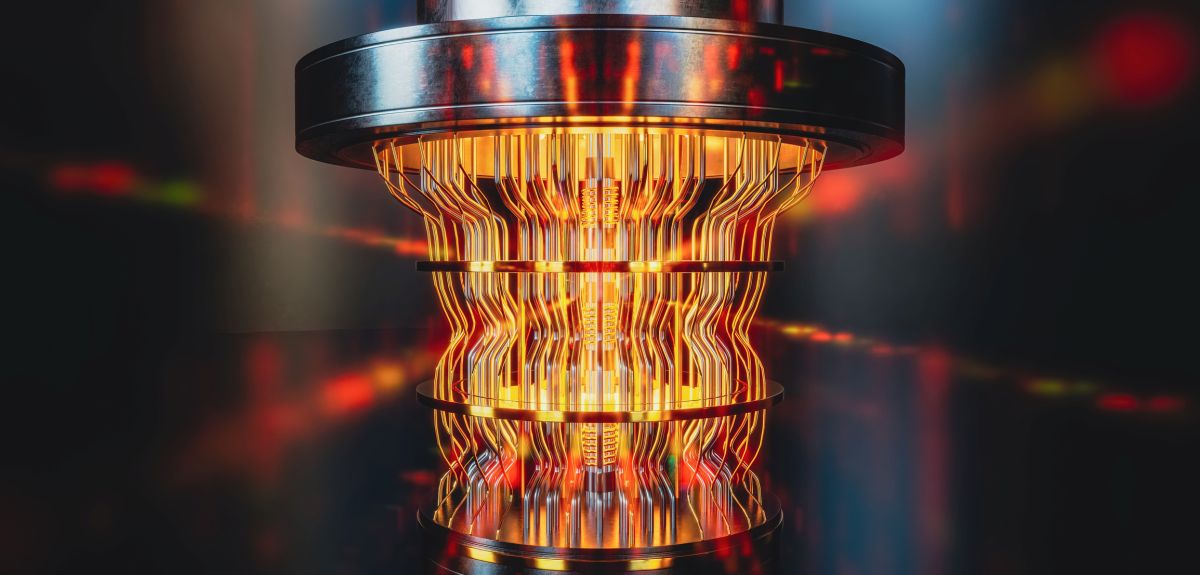 A futuristic glowing quantum computer unit. It resembles a network of interconnected wires extending downwards from a cylindrical component.