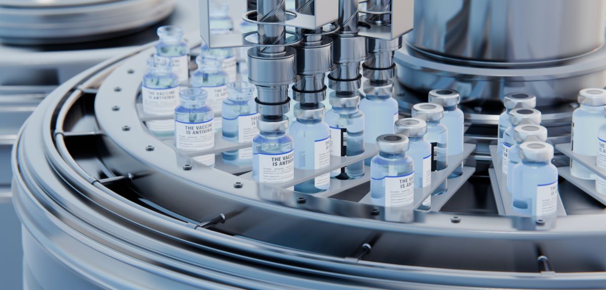 A pharmaceutical plant, showing vaccine vials being filled from above with solution.