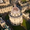 High angle drone shot of the Radcliffe Camera and All Souls College, historic University of Oxford buildings in the centre of Oxford.