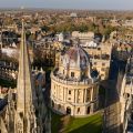 High angle aerial view of St Mary's Church and the Radcliffe Camera (a large ornate circular building) in Oxford.