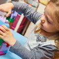 Child plays with building bricks at nursery school
